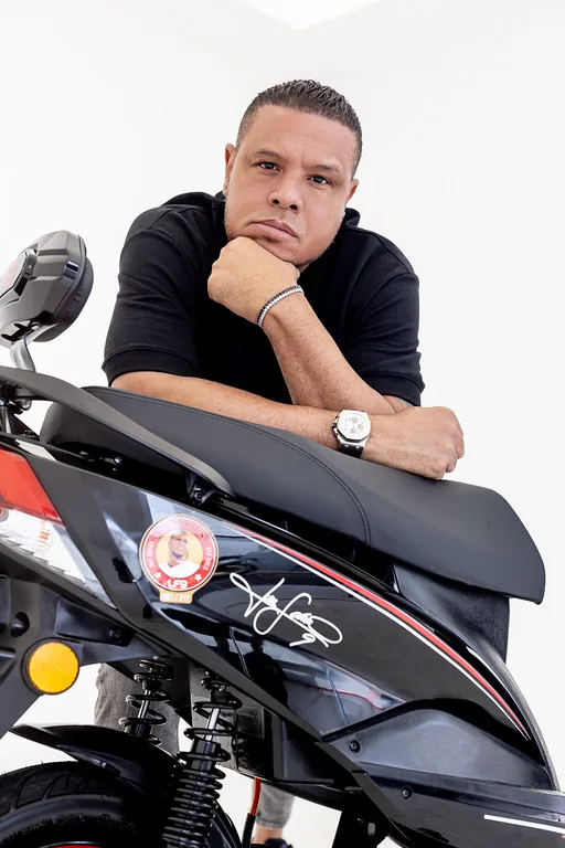 Luis Fabiano apoiado no banco da LF9, com o emblema 001/212 em primeiro plano